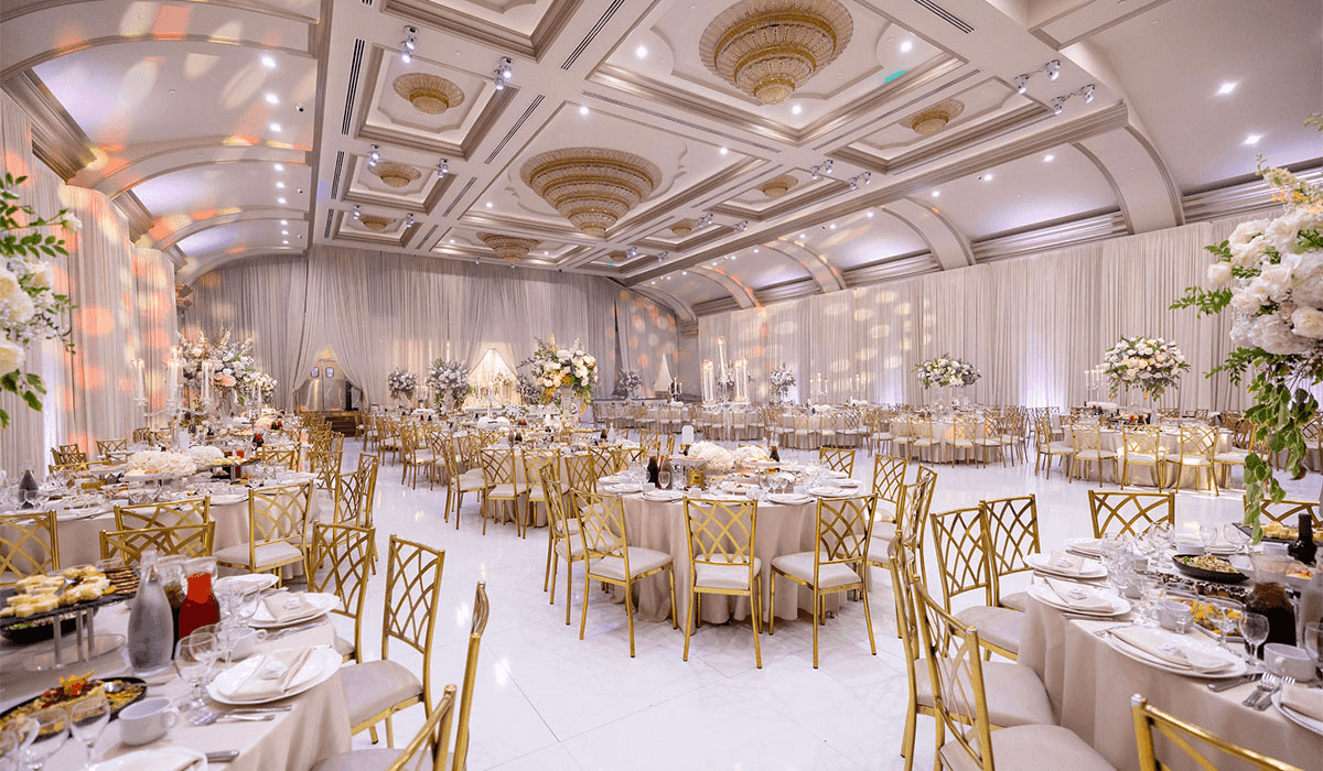 Elegant banquet hall with gold-accented chairs, floral centerpieces, and luxurious decor, perfect for events and celebrati...