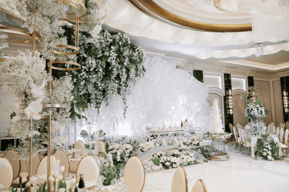 Elegant white floral decor with cascading arrangements and soft lighting in a sophisticated event space.
